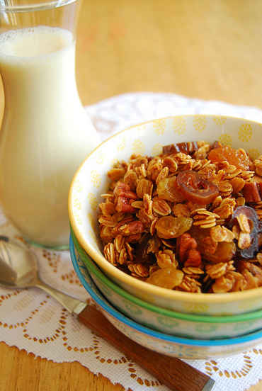 Milk in a glass with oats and dried fruit in a bowl